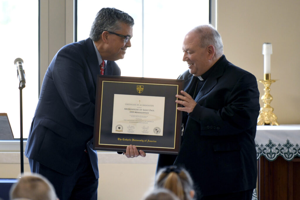 Dr. Peter Kilpatrick, president of The Catholic University of America, presents a Lumen Accreditation certificate for the Archdiocese of Saint Paul and Minneapolis’ system of Catholic schools to Archbishop Bernard Hebda.