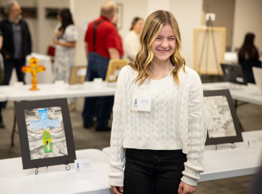 Catholic school student with Eucharistic artwork for visual arts exhibition