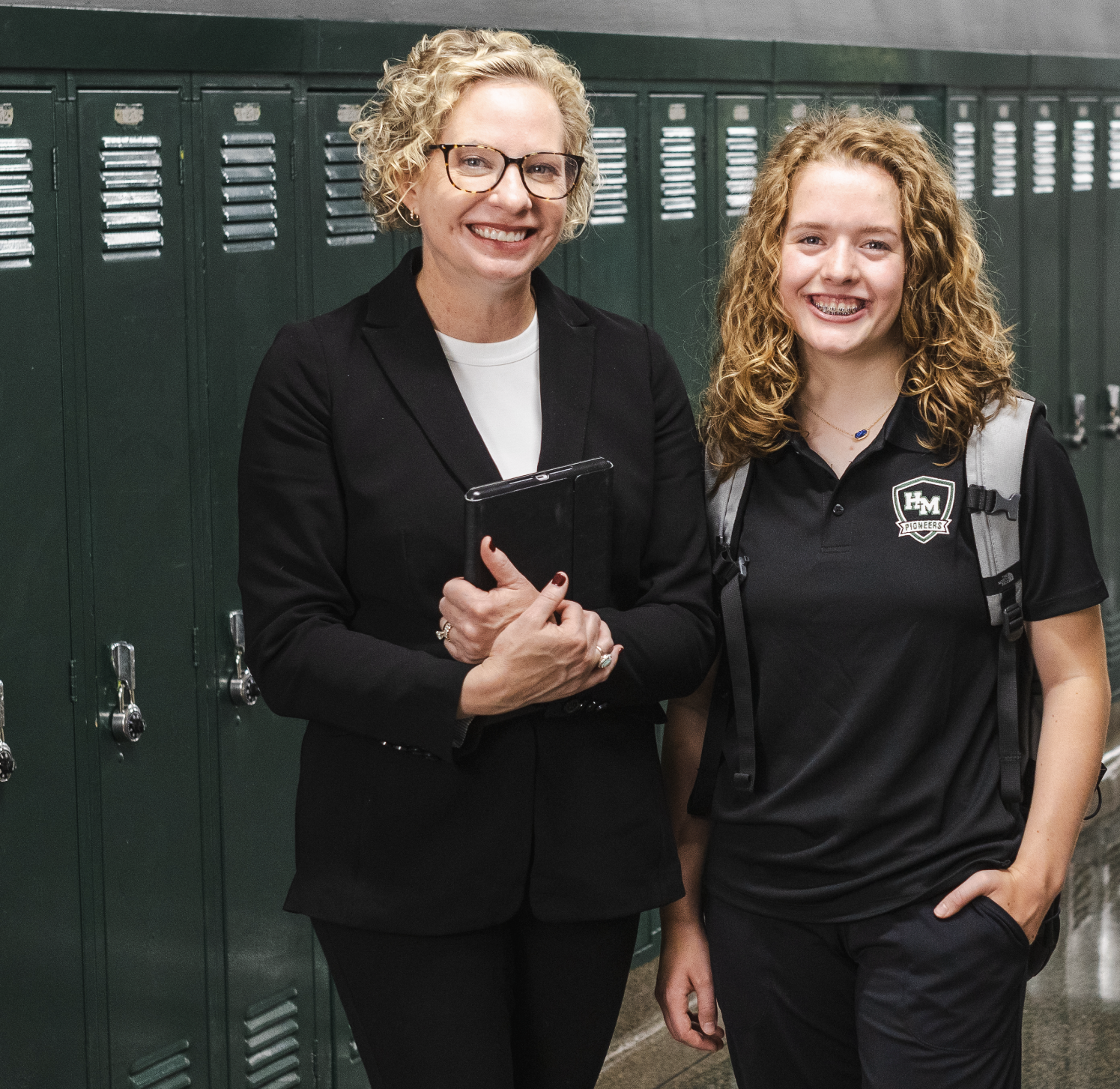 Catholic school president and student standing in school hallway
