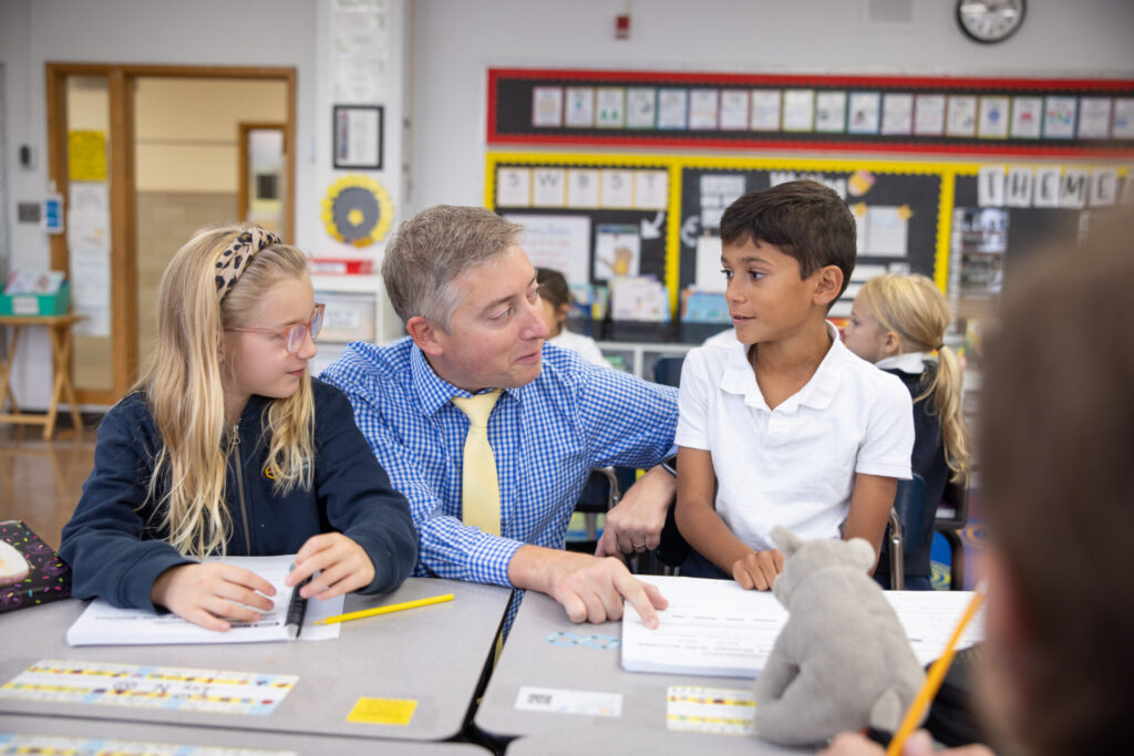 Principal Adam Groebner with Catholic school students in a classroom